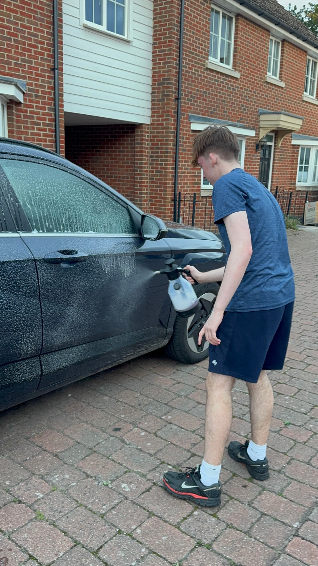 Fine & Line detailer pre-washing a car on a driveway